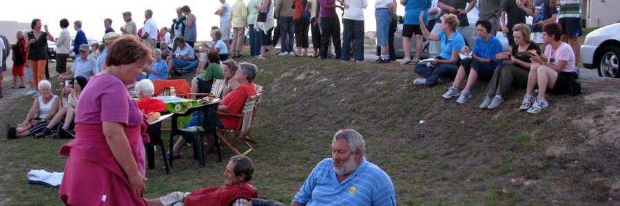 Welkome versnapperinge aan die einde van die Skemerstap op Strandveld Museum se grasperk, met laatkommers wat nog toustaan om die dors en die honger te les.  (Argieffoto: Gansbaai Courant)